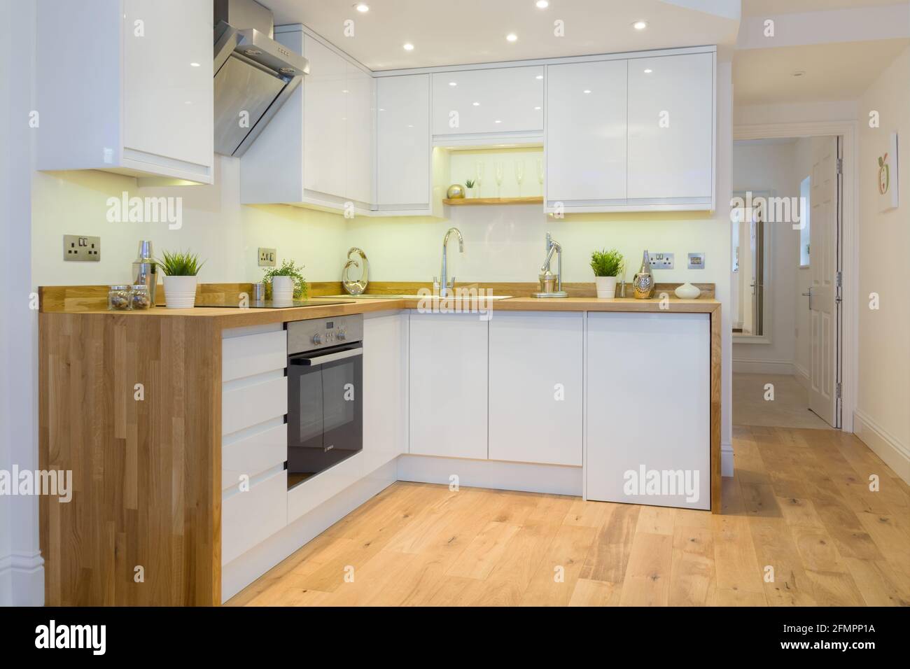 Un moderno appartamento cucina con ripiani in legno armadi prima colazione bar e elettrodomestici da cucina Foto Stock