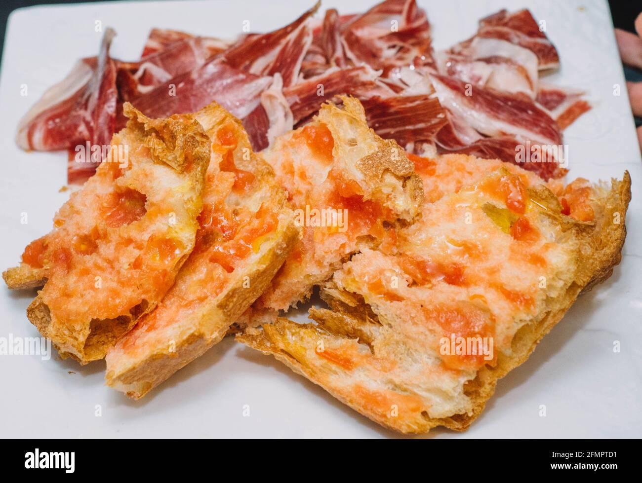 Una porzione del prosciutto iberico di migliore qualità accompagnato da pane fatto in casa toast Foto Stock