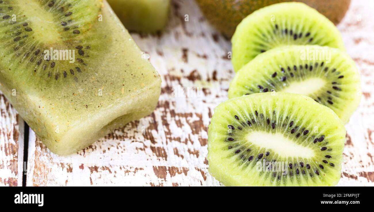 Ciotola di vaniglia e yogurt kiwi popsicle su bianco rustico sfondo di legno Foto Stock