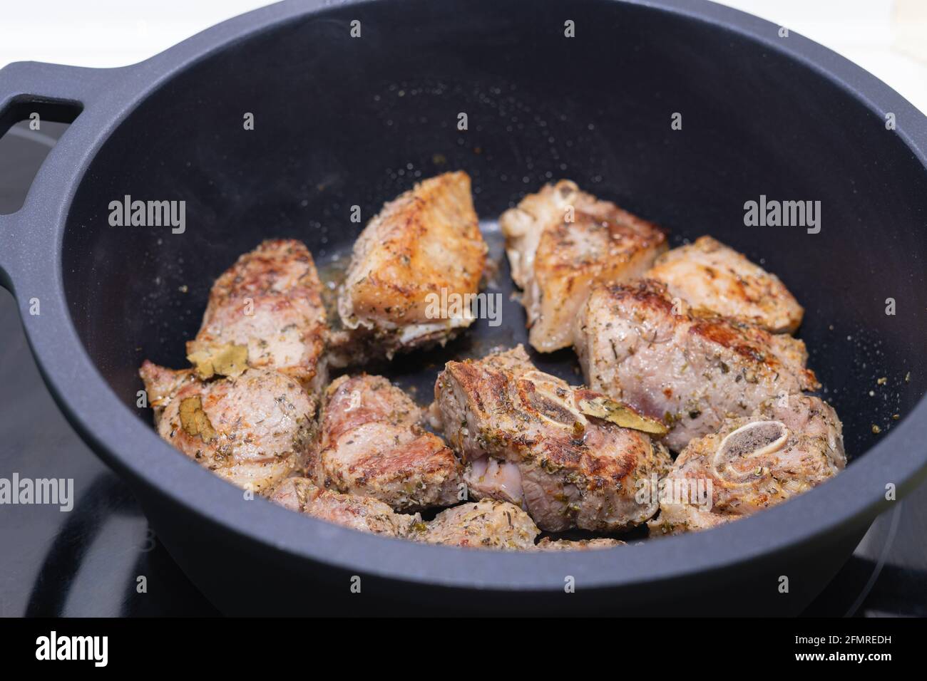 Carne cucinata in una pentola nera. Concetto di cucina. Foto Stock
