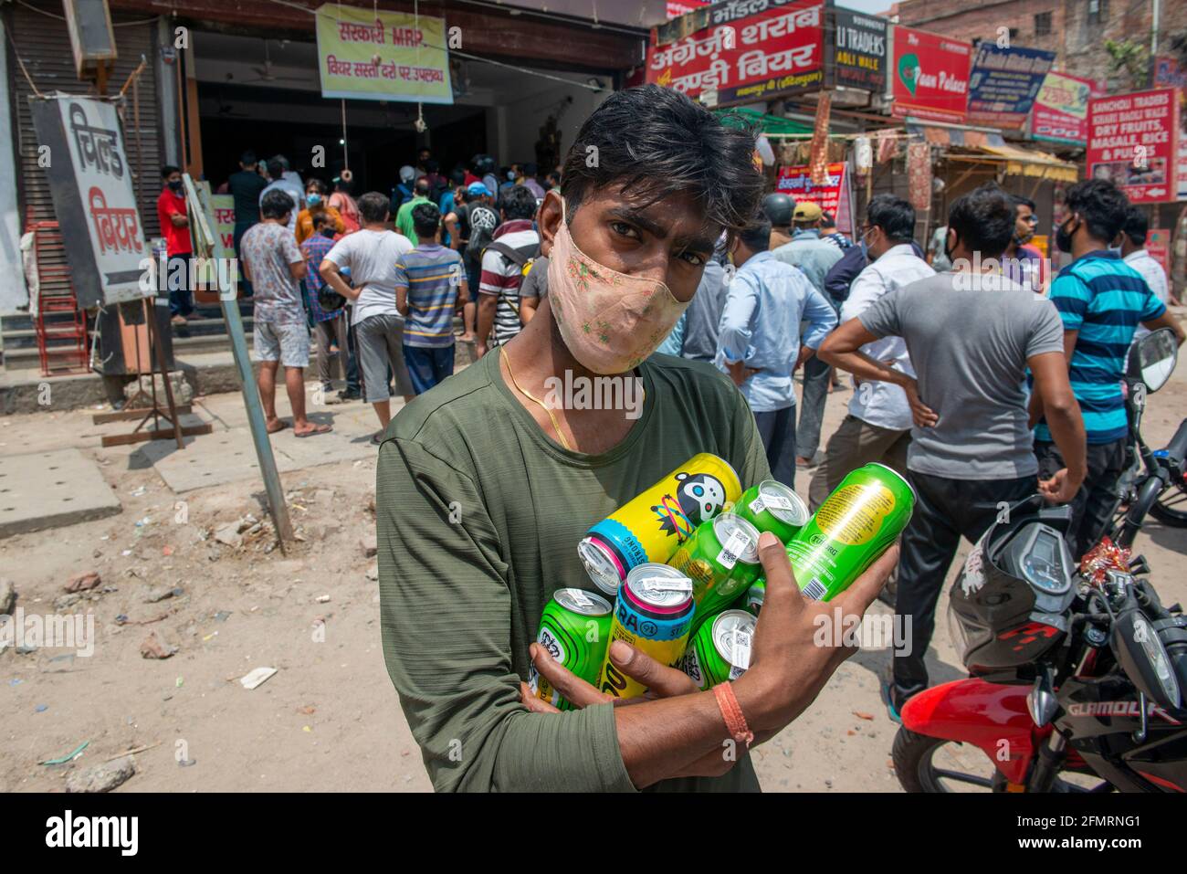 Ghaziabad, India. 11 Maggio 2021. Un giovane uomo ha visto trasportare parecchie lattine di birra dopo la riapertura dei negozi di liquori in parecchi distretti di Uttar Pradesh. I negozi di liquori sono autorizzati ad operare dalle 10:00 alle 19:00 in mezzo alla pandemia COVID19. Nelle ultime 24 ore Uttar Pradesh ha registrato 21,277 casi COVID19 positivi e 278 decessi. Credit: SOPA Images Limited/Alamy Live News Foto Stock