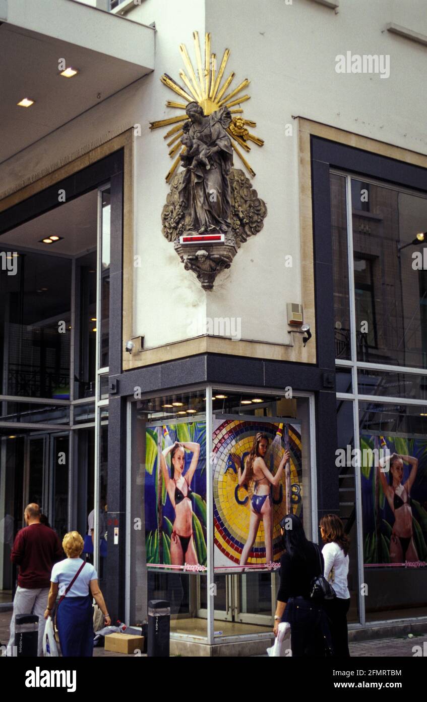 Paradiso e inferno, tradizione e tempi moderni in una via commerciale di Anversa. Foto Stock