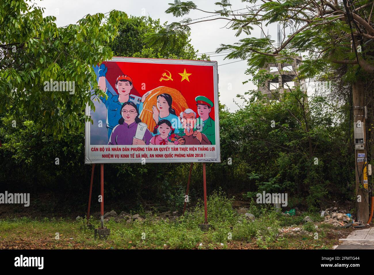 Colorato manifesto di propaganda comunista vietnamita sul lato della strada, Hoi An, Vietnam Foto Stock