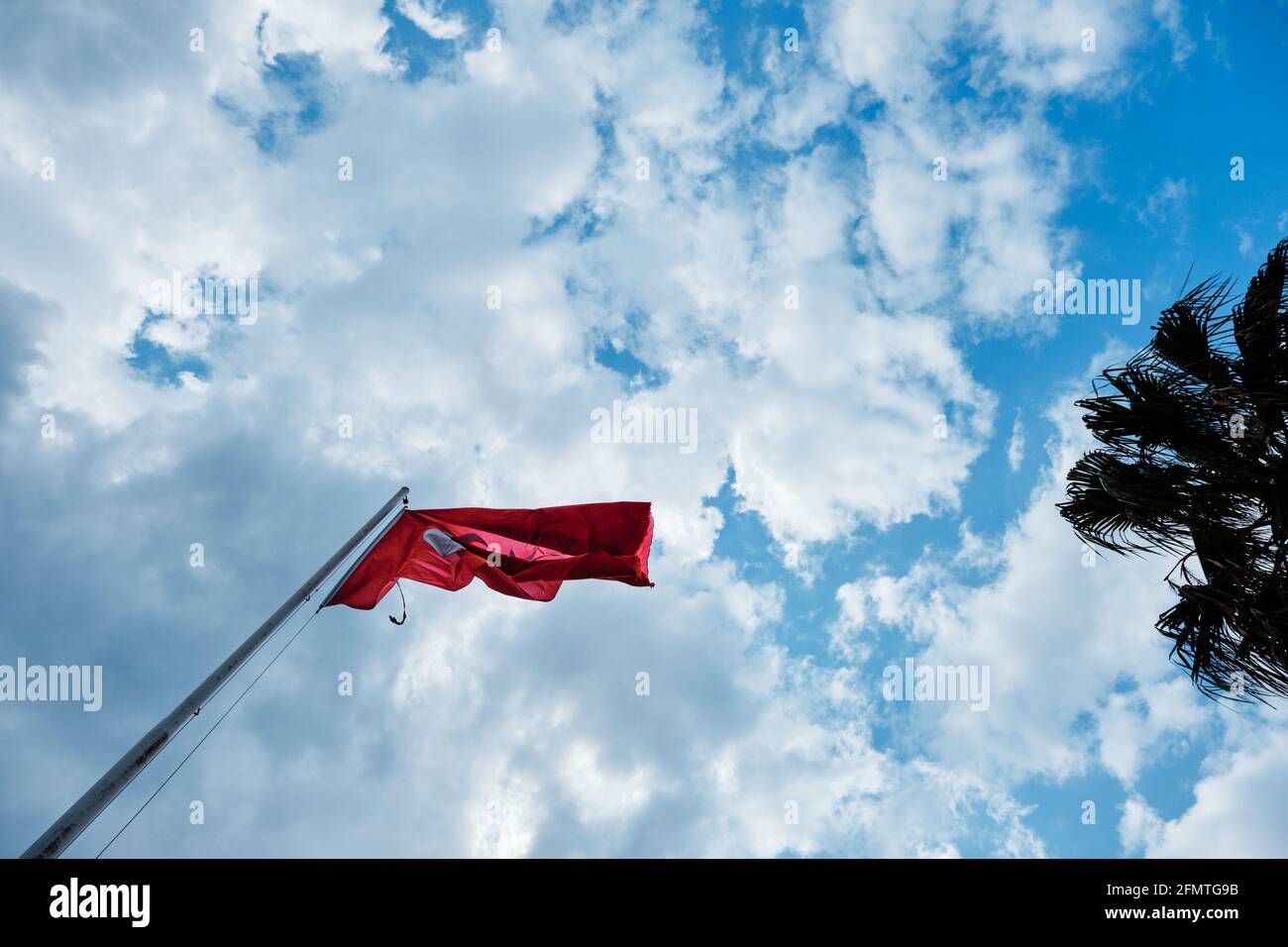 Enorme bandiera turca con sfondo cielo nuvoloso sovrastato. La bandiera è lacerata Foto Stock