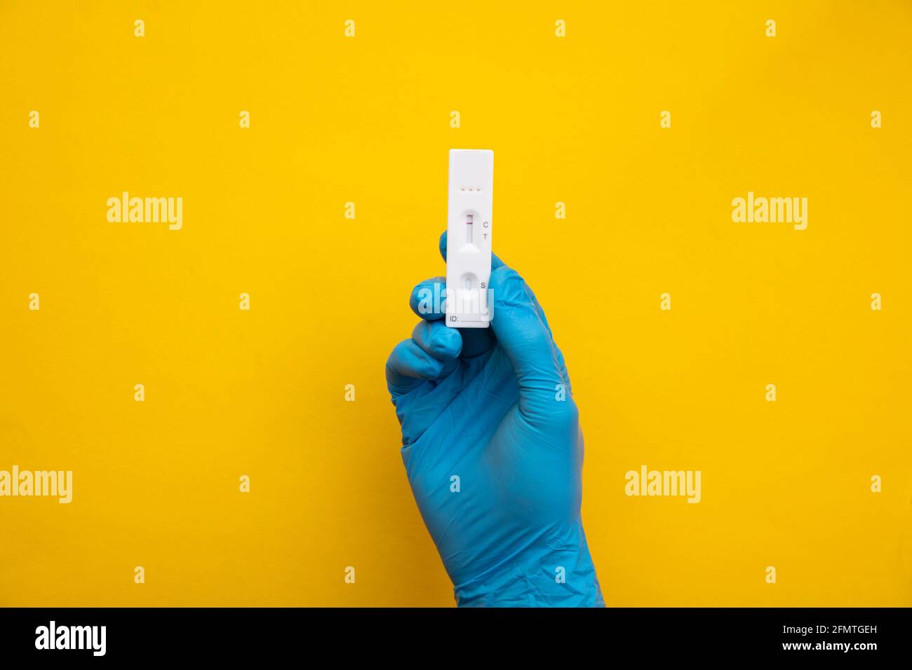 Persona che indossa guanti blu con un test di flusso laterale del coronavirus Foto Stock