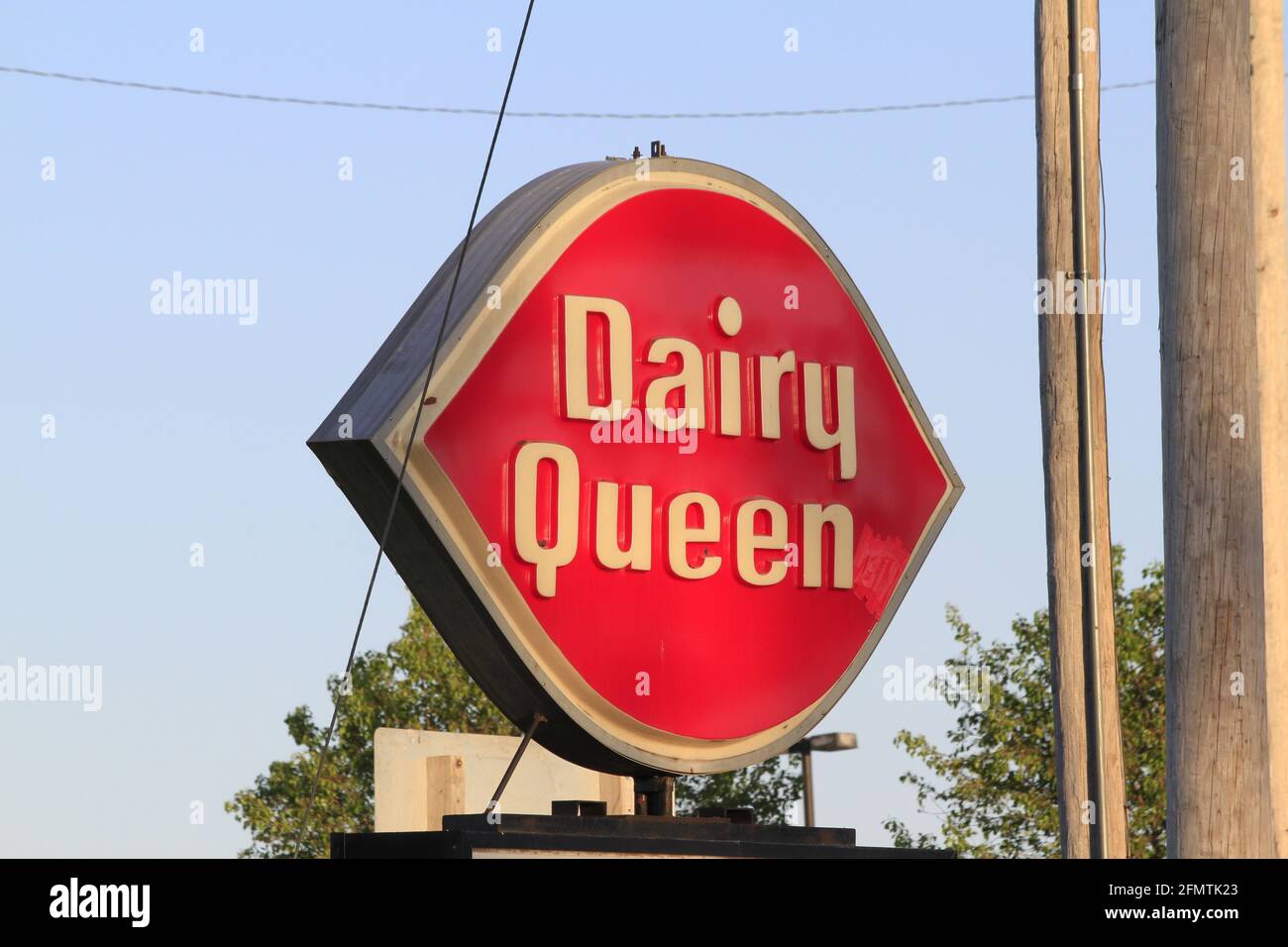 Dairy Queen segno girato closeup su un palo di metallo con cielo blu in Kansas. Foto Stock