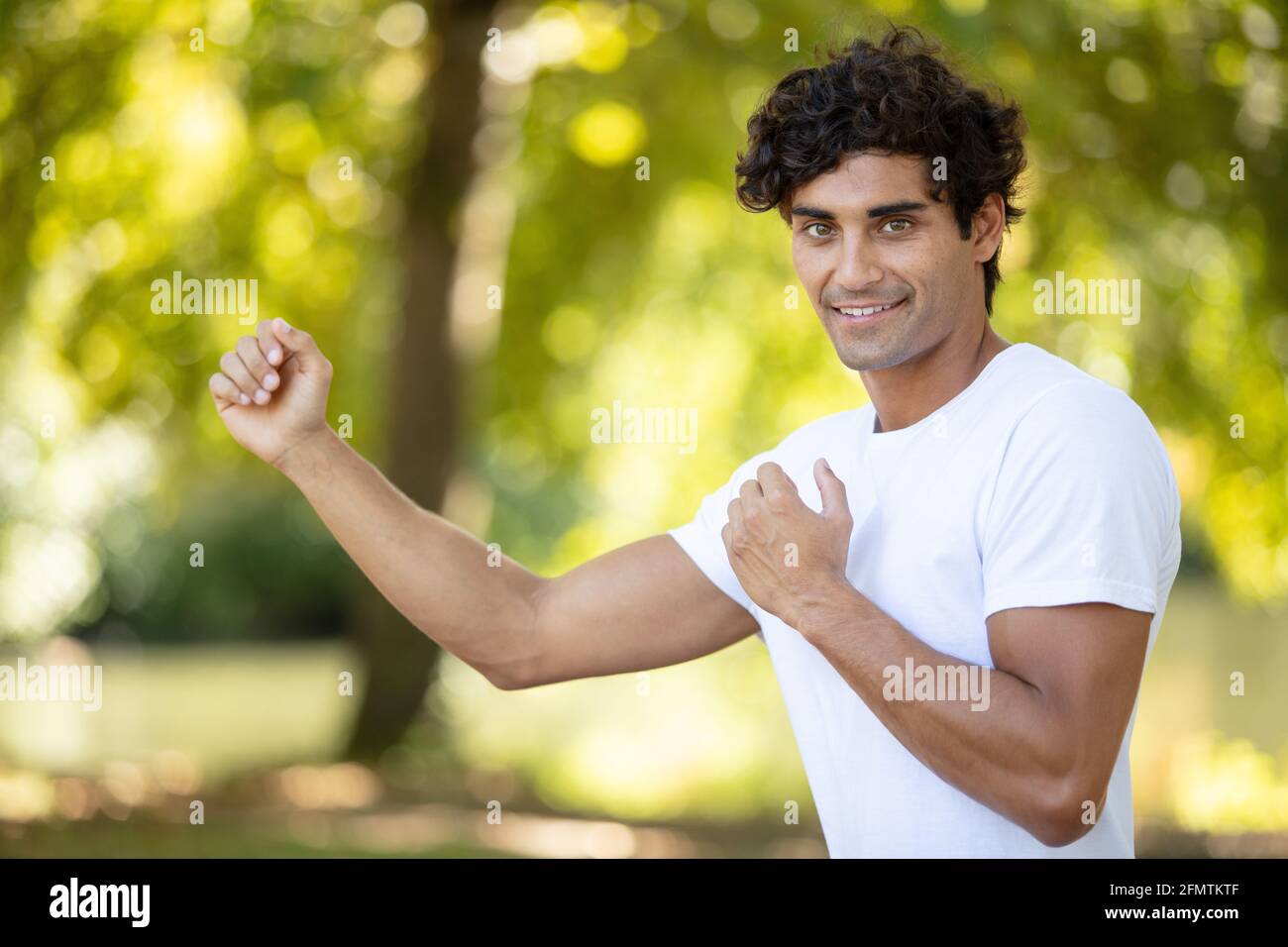 uomo sorridente in posa di combattimento di arti marziali Foto Stock