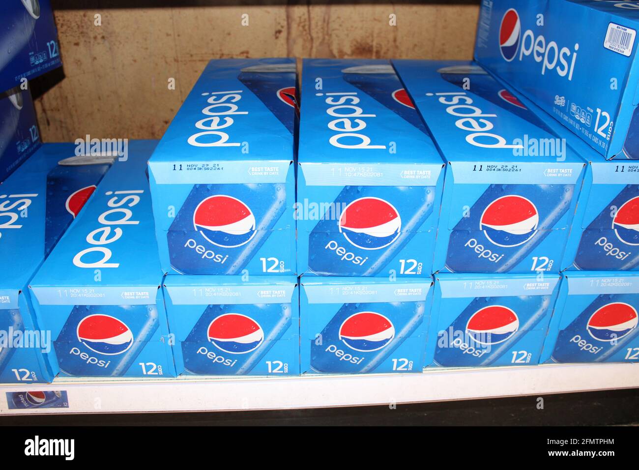 Pepsi in cartone che è luminoso e colorato su un ripiano di metallo in un negozio di alimentari in Kansas che è luminoso e colorato primo piano shot. Foto Stock