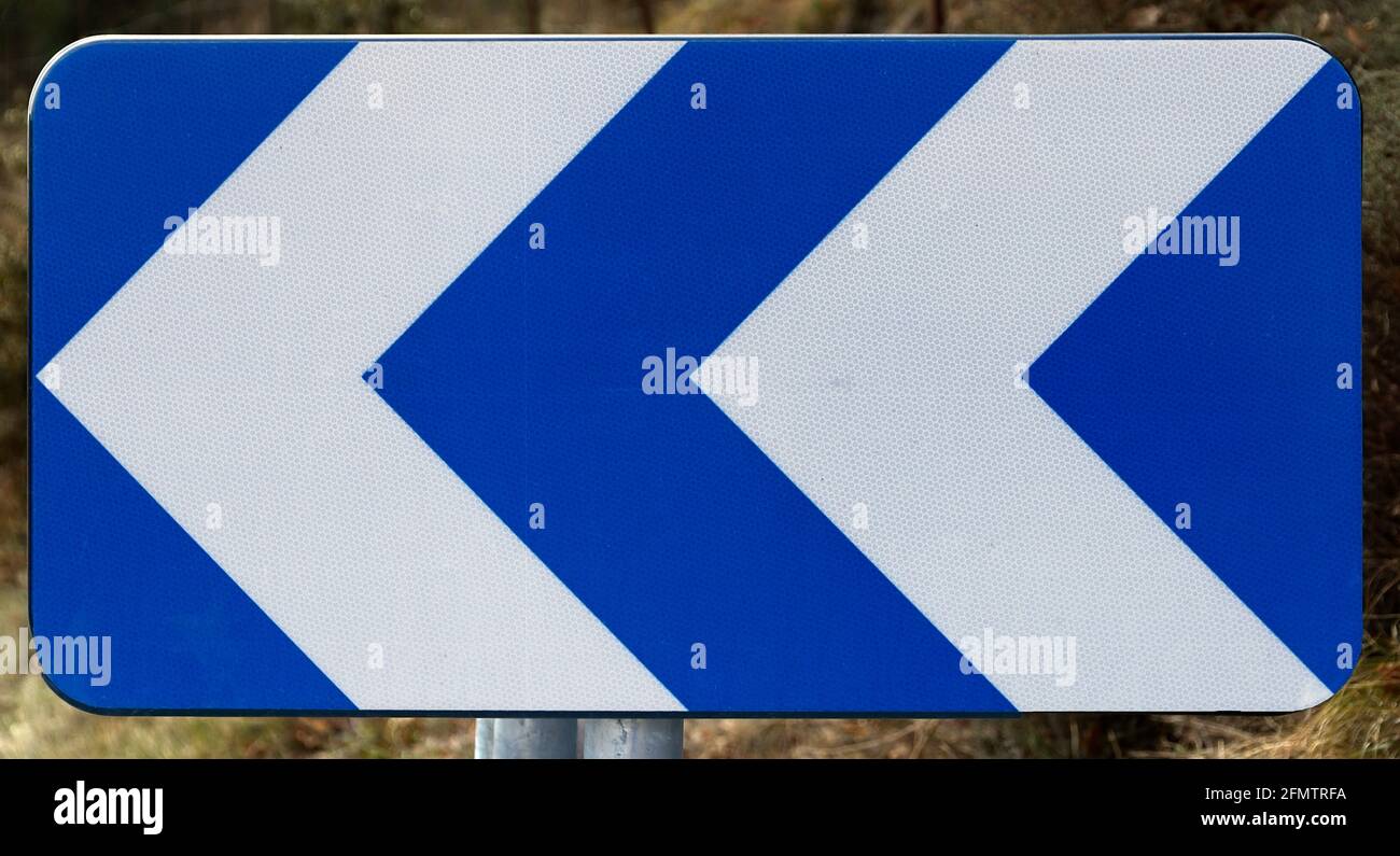 indicatore di direzione pericoloso verso la strada Foto Stock