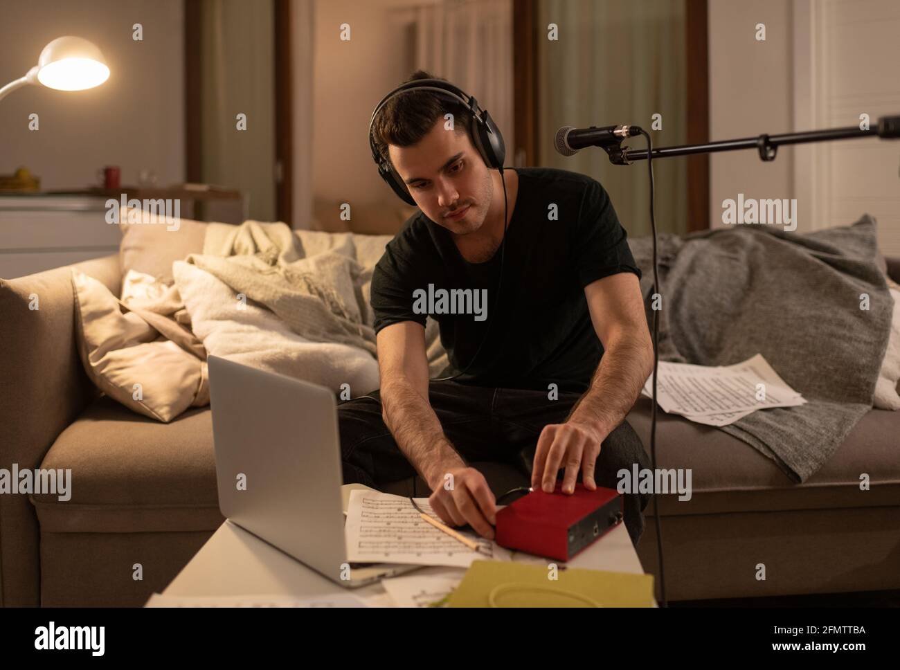 Musicista maschile che si prepara per la lezione online a casa Foto Stock