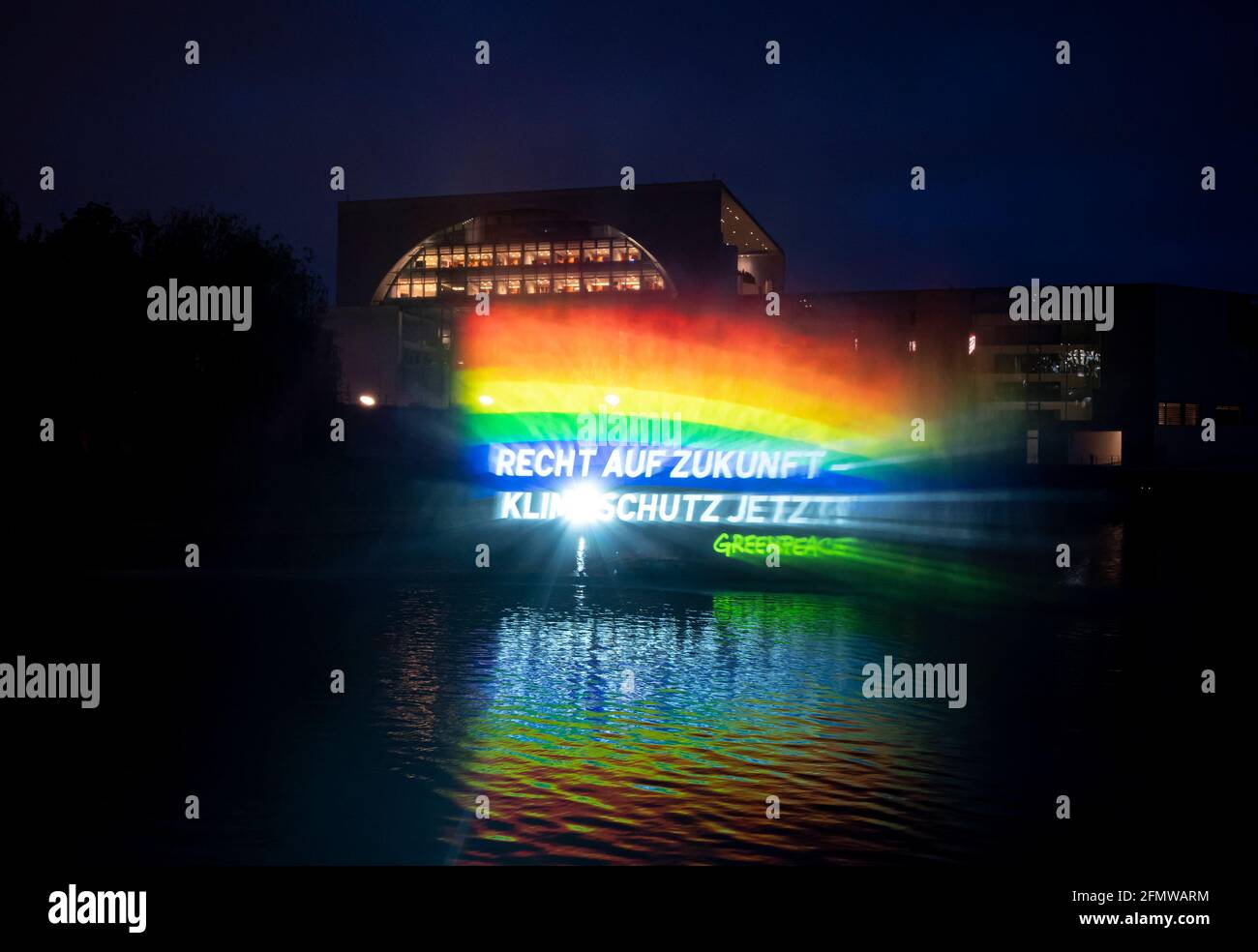 Berlino, Germania. 05 dicembre 2021. Sul fiume Sprea, di fronte alla Cancelleria federale, un idro segno di circa 15 metri di altezza è stato creato da un gommone utilizzando una pompa ad alta pressione, con le parole 'diritto al futuro - protezione del clima ora!' scritto su di esso. L'azione di Greenpeace si svolge in occasione dell'odierna riunione del governo federale, in occasione della quale verrà approvata una nuova versione della legge sulla protezione del clima. Credit: Fabian Sommer/dpa/Alamy Live News Foto Stock