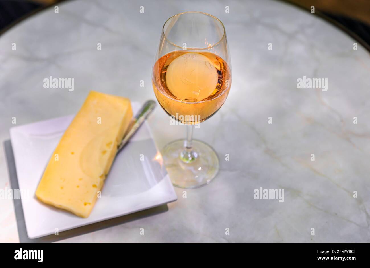 Bicchiere di vino rosato frizzante su un tavolo esterno e un piatto di formaggi in un vigneto in primavera nella Napa Valley, California, USA Foto Stock