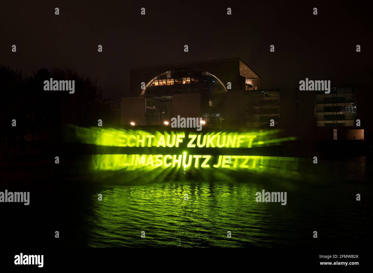 Berlino, Germania. 05 dicembre 2021. Sul fiume Sprea, di fronte alla Cancelleria federale, un idro segno di circa 15 metri di altezza è stato creato da un gommone utilizzando una pompa ad alta pressione, con le parole 'diritto al futuro - protezione del clima ora!' scritto su di esso. L'azione di Greenpeace si svolge in occasione dell'odierna riunione del governo federale, in occasione della quale verrà approvata una nuova versione della legge sulla protezione del clima. Credit: Fabian Sommer/dpa/Alamy Live News Foto Stock