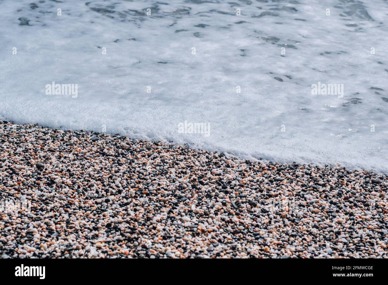 Astratto natura estate o primavera mare sfondo. Piccole onde sulla superficie dorata dell'acqua calda in movimento sfocano con le luci bokeh dal tramonto. Vacanze Foto Stock