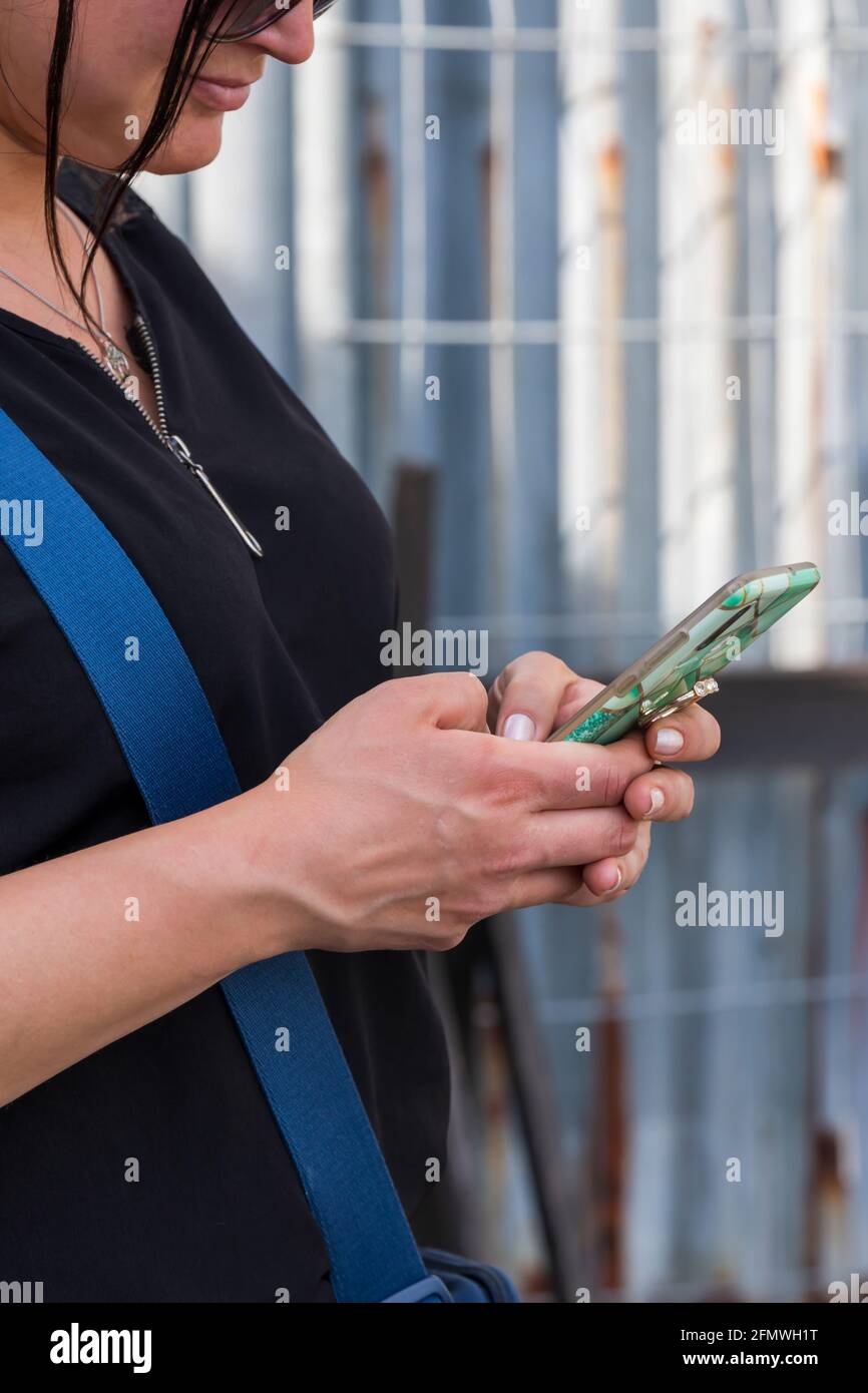 La giovane donna inserisce il messaggio nello smartphone Foto Stock
