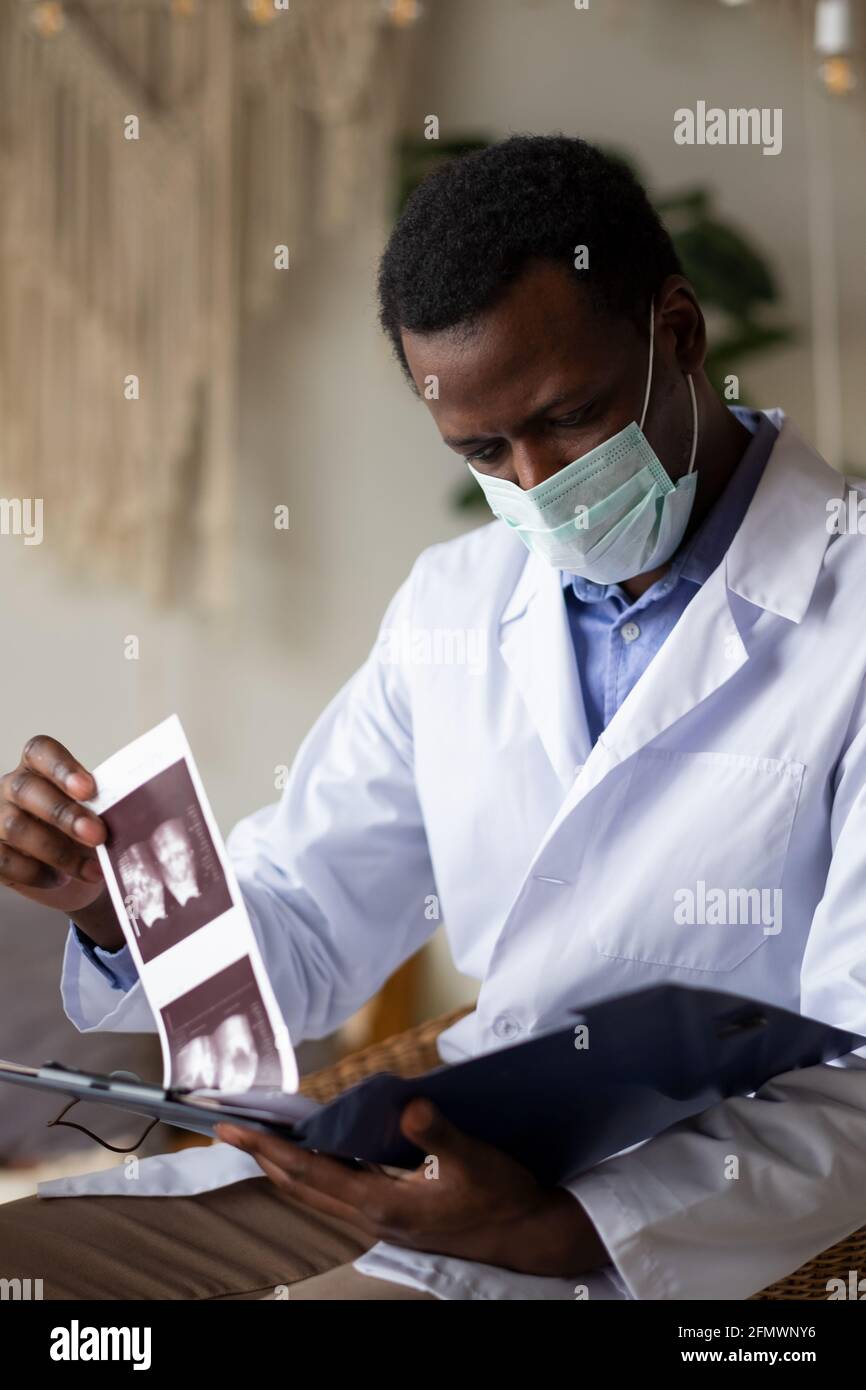 Medico africano che analizza i risultati ecografici del suo pacient. Foto Stock