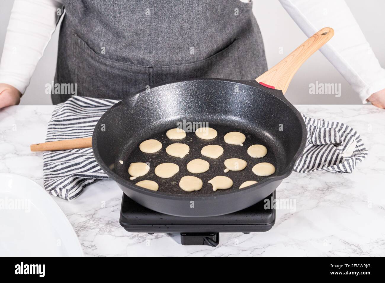 Frittura di cereali mini pancake in una padella antiaderente Foto stock -  Alamy
