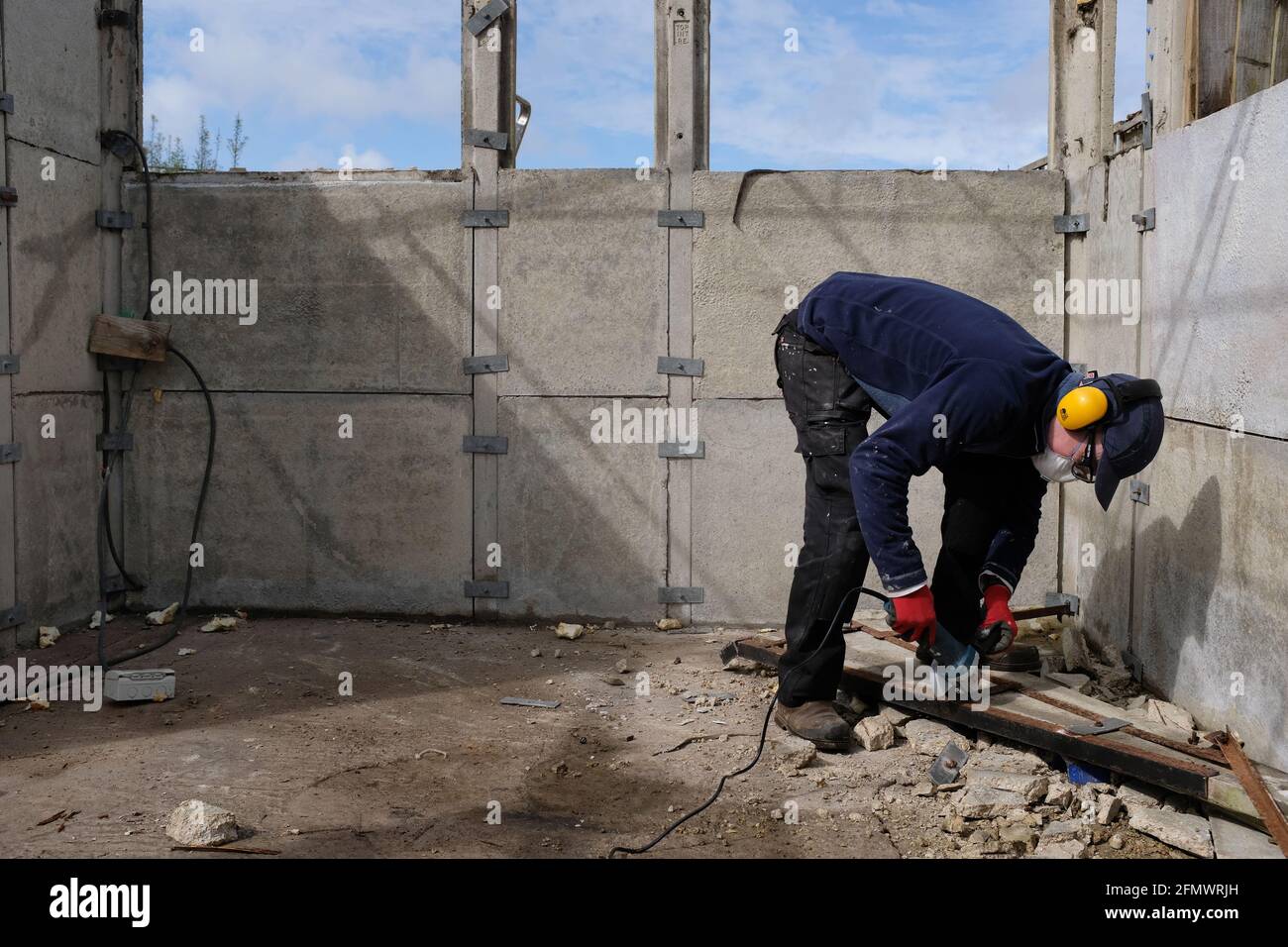 Un uomo che smantellava il suo vecchio garage. Foto Stock