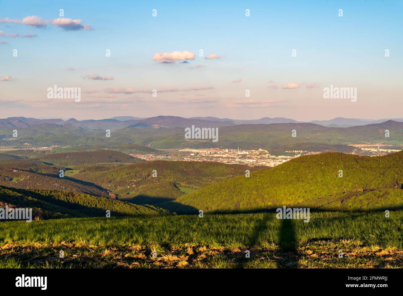 Trencin città con colline intorno dalla cima collina Machnac in Le montagne di Biele Karpaty in Slovacchia durante la bella serata primaverile Foto Stock