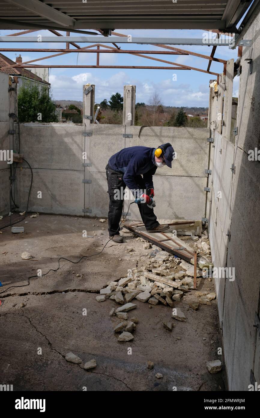 Un uomo che smantellava il suo vecchio garage. Foto Stock