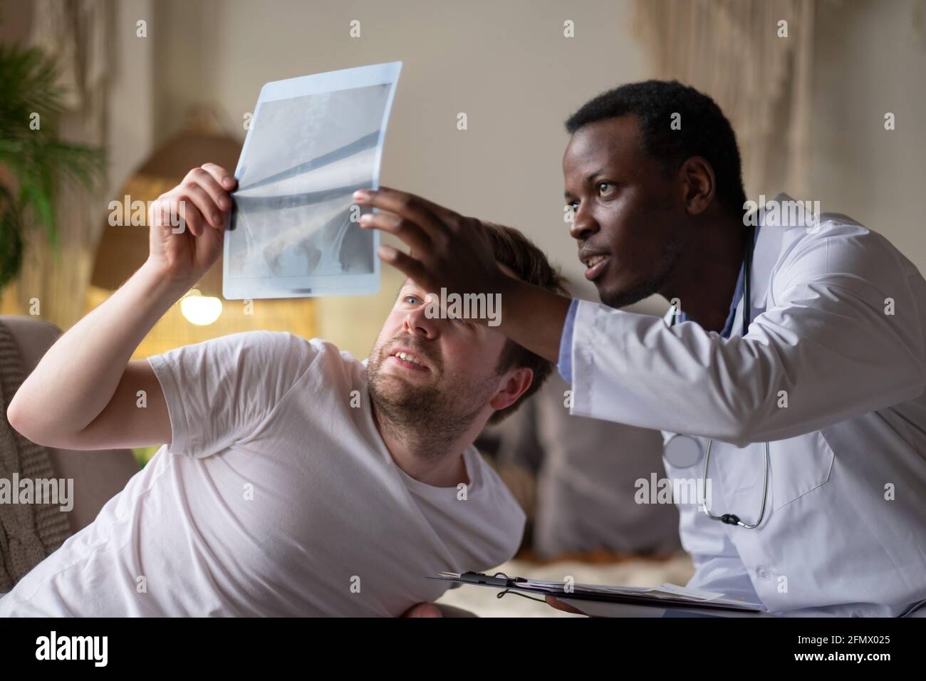 Medico africano che analizza i risultati ecografici del suo pacient. Foto Stock