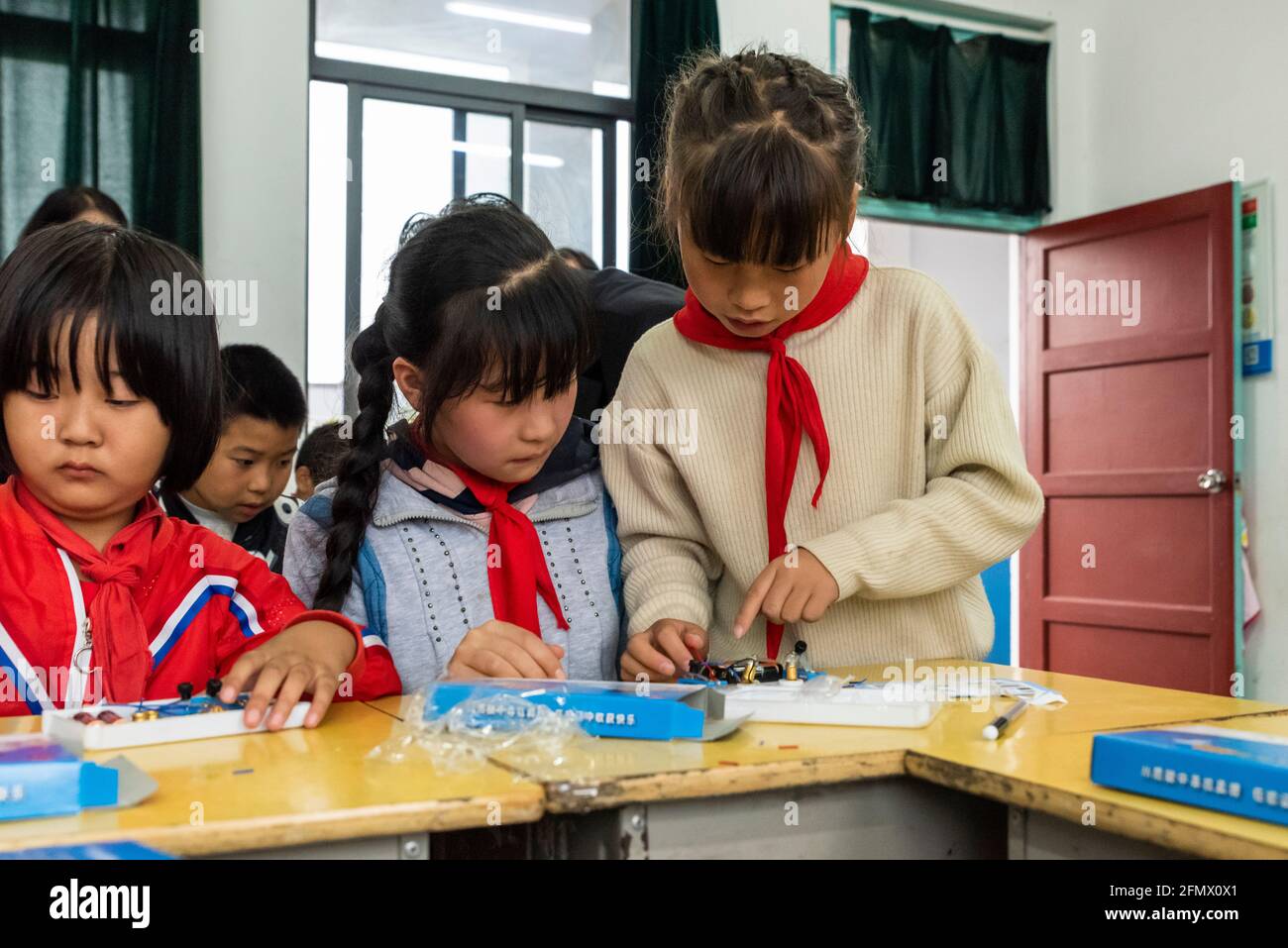 Gli studenti primari di una scuola rurale di Xianing, Anhui, Cina, stanno imparando a conoscere l'elettricità e come il circuito elettrico. Foto Stock