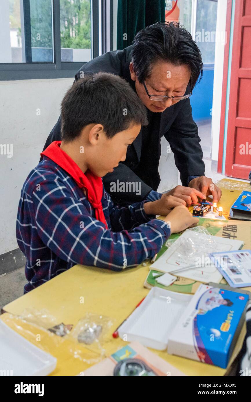 Gli studenti primari di una scuola rurale di Xianing, Anhui, Cina, stanno imparando a conoscere l'elettricità e come il circuito elettrico. Foto Stock