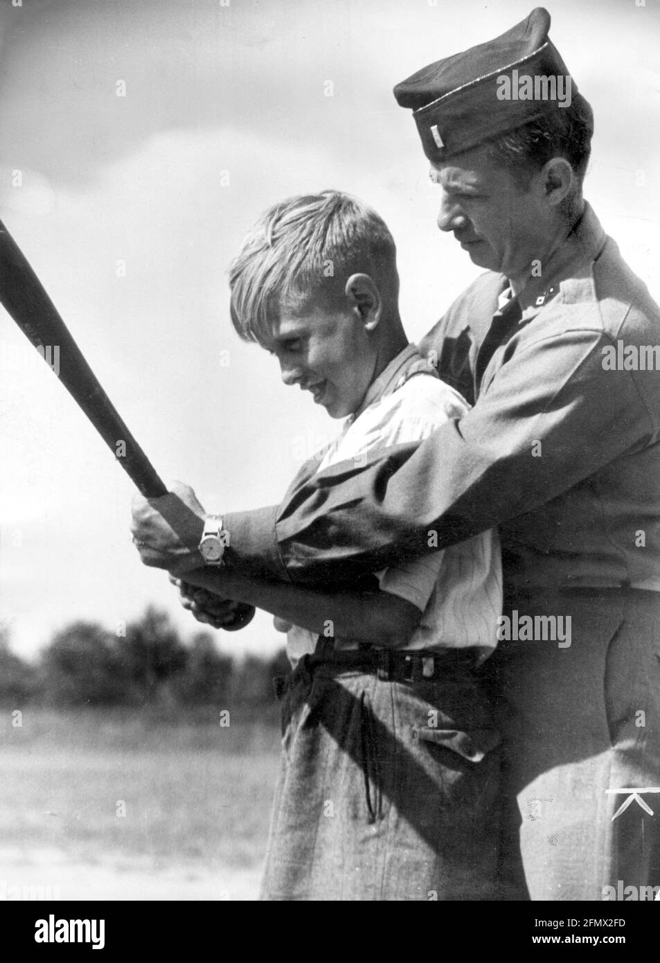 Periodo del dopoguerra, occupazione alleata della Germania, ufficiale degli Stati Uniti che insegna a un ragazzo tedesco come giocare a baseball, INFORMAZIONI-DIRITTI-AGGIUNTIVI-DI-LIQUIDAZIONE-NON-DISPONIBILI Foto Stock