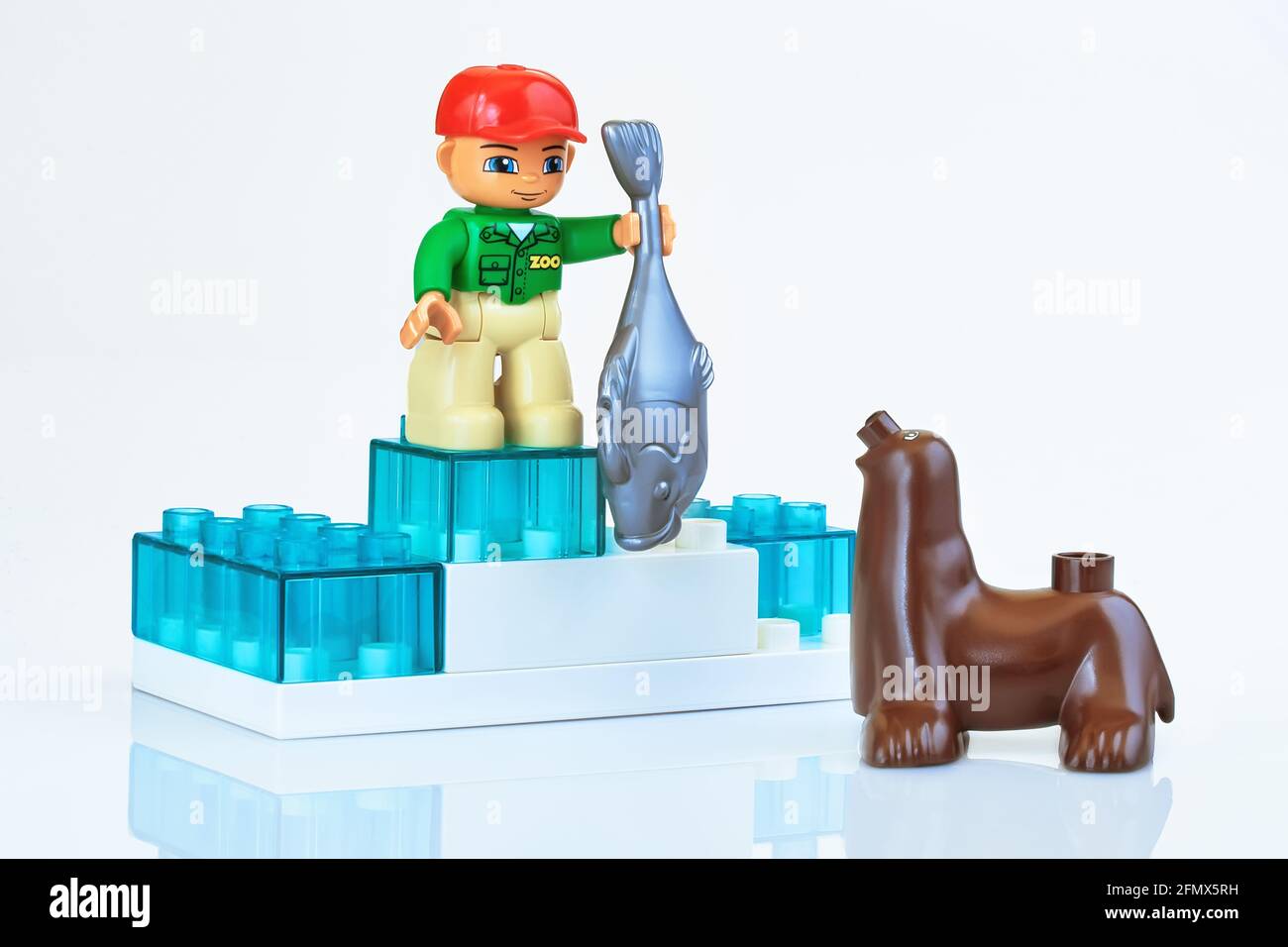 KHARKIV, UCRAINA - 29 marzo 2020: Giocattolo uomo che alimenta il sigillo giocattolo, giocattoli di plastica, tema di educazione prescolare, isolato su bianco Foto Stock