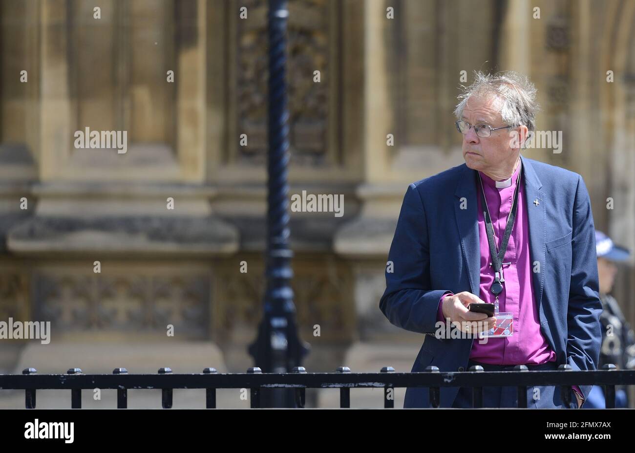Il reverendo di destra Paul Butler, Vescovo di Durham sul suo cellulare fuori dal Parlamento dopo il discorso della Regina all'apertura dello Stato, 11 maggio 2021 Foto Stock