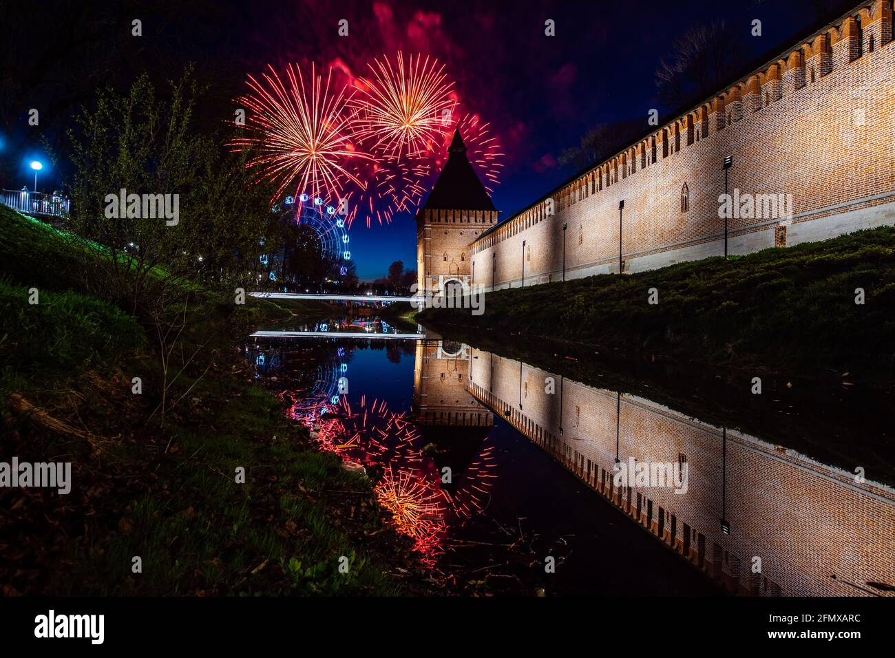 un divertente festival della città termina con un festoso spettacolo di fuochi d'artificio. le colorate esplosioni di fuochi d'artificio nel cielo serale si riflettono nell'acqua Foto Stock