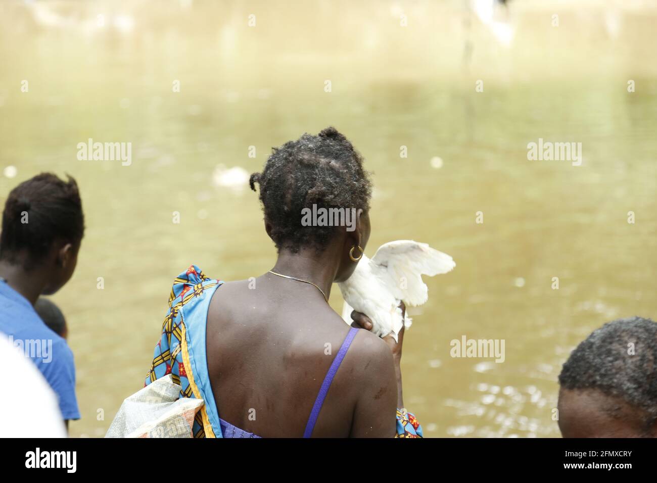 Osun Osogbo: Una donna che prega con una colomba e una gallina sacrificali durante il Festival Osun Osogbo. Foto Stock