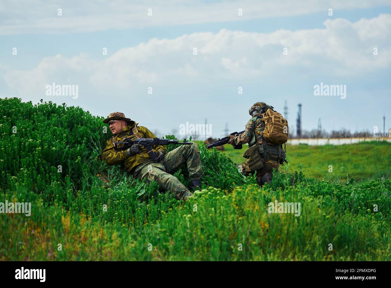 I giocatori di Airsoft si nascondono dietro la copertura durante la battaglia il campo Foto Stock