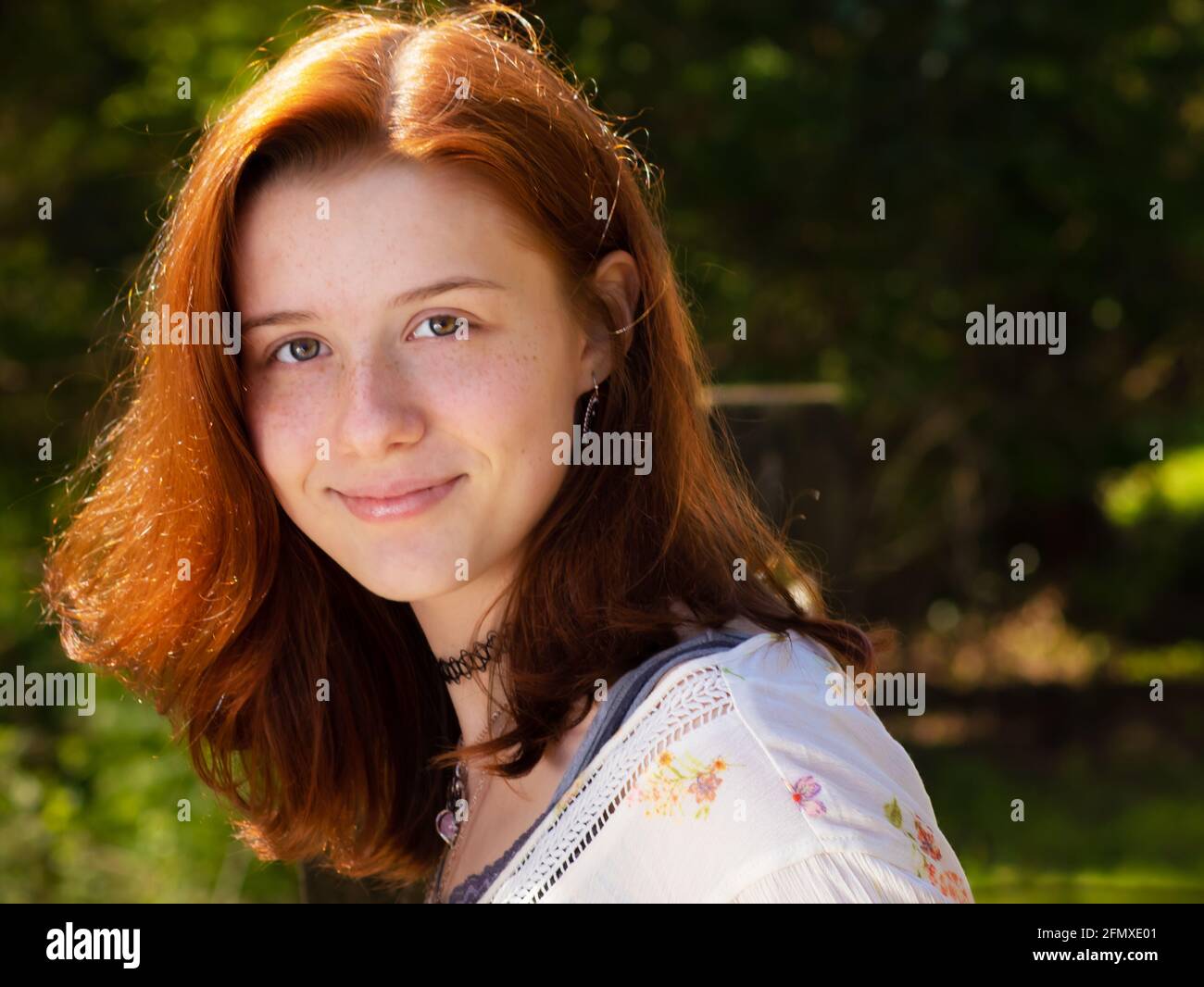 Bella ragazza di scuola superiore con capelli rossi o college con occhi verdi blu in posa in legno in abbigliamento casual durante l'estate a Lancaster County, Pennsylvania Foto Stock