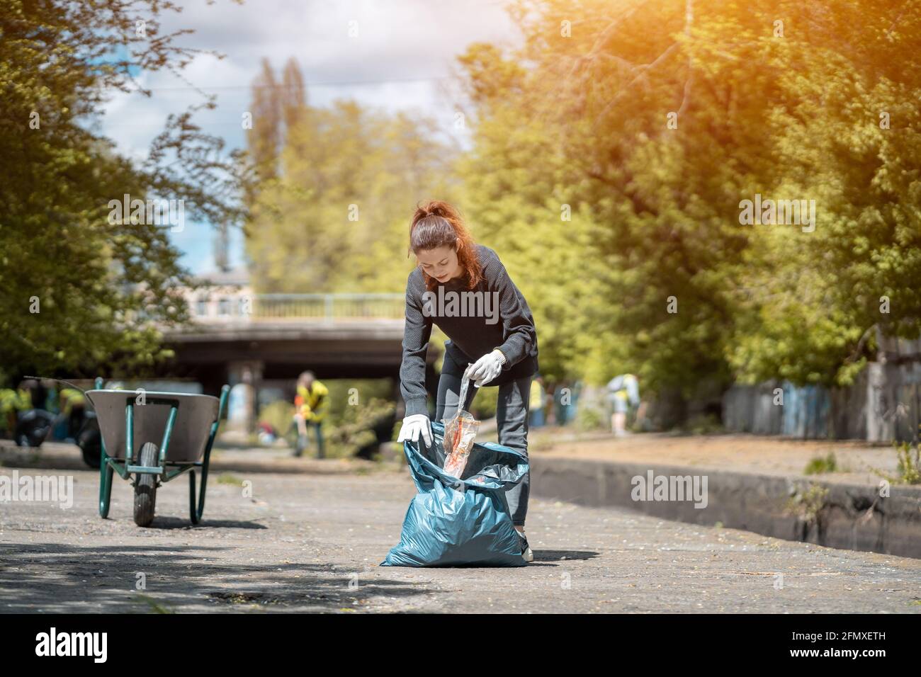 volontariato donna pulizia su parco e albero da lettiera di plastica con sacchetto per rifiuti Foto Stock