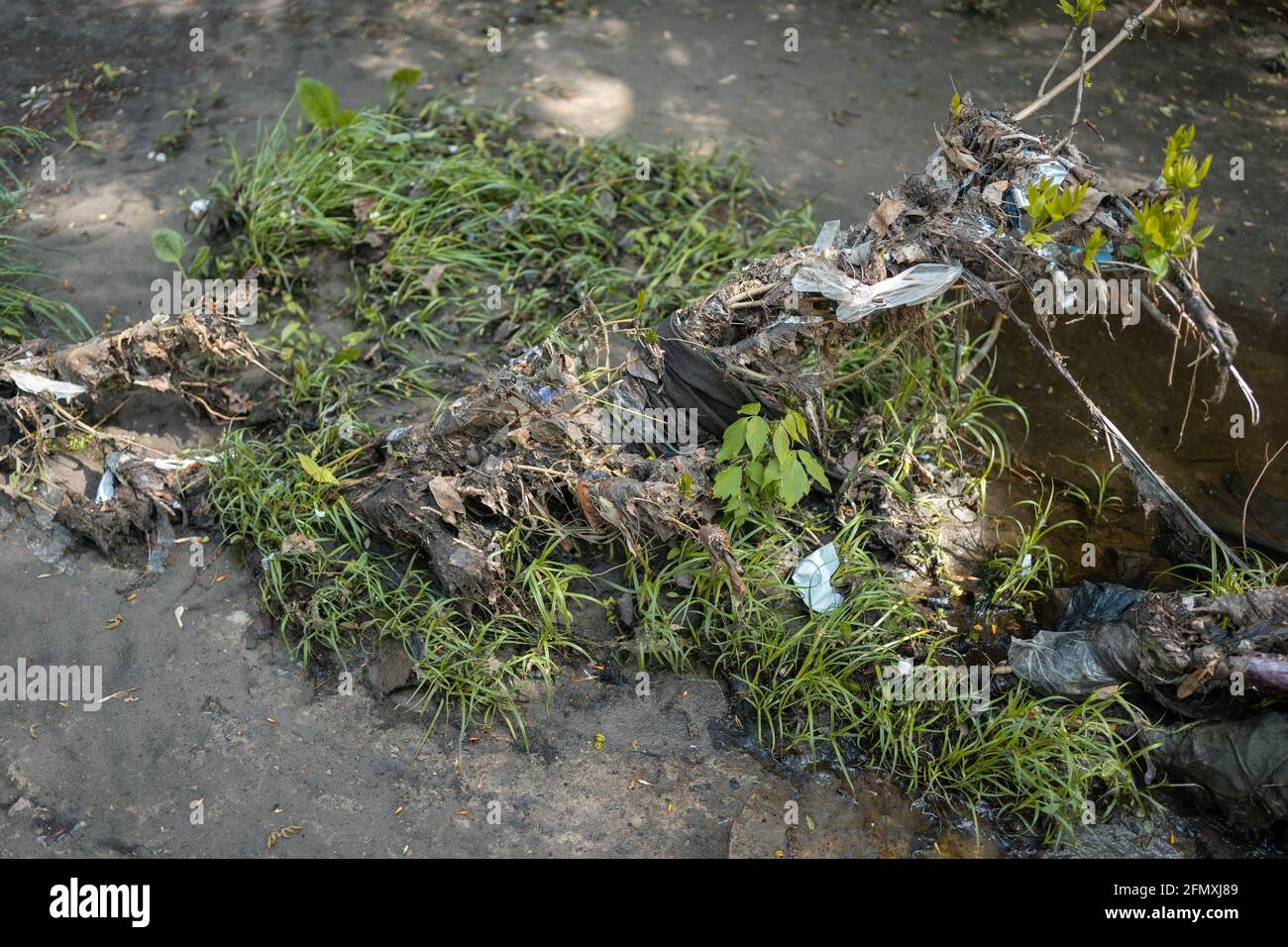 rifiuti, sacchi di plastica e rifiuti sulla città industriale fiume dopo l'alluvione di primavera Foto Stock