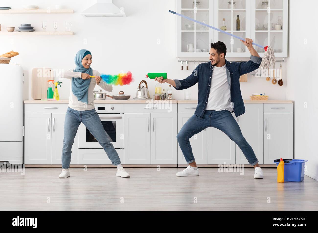 Divertente uomo medio-orientale e donna che si divertono durante la pulizia Foto Stock