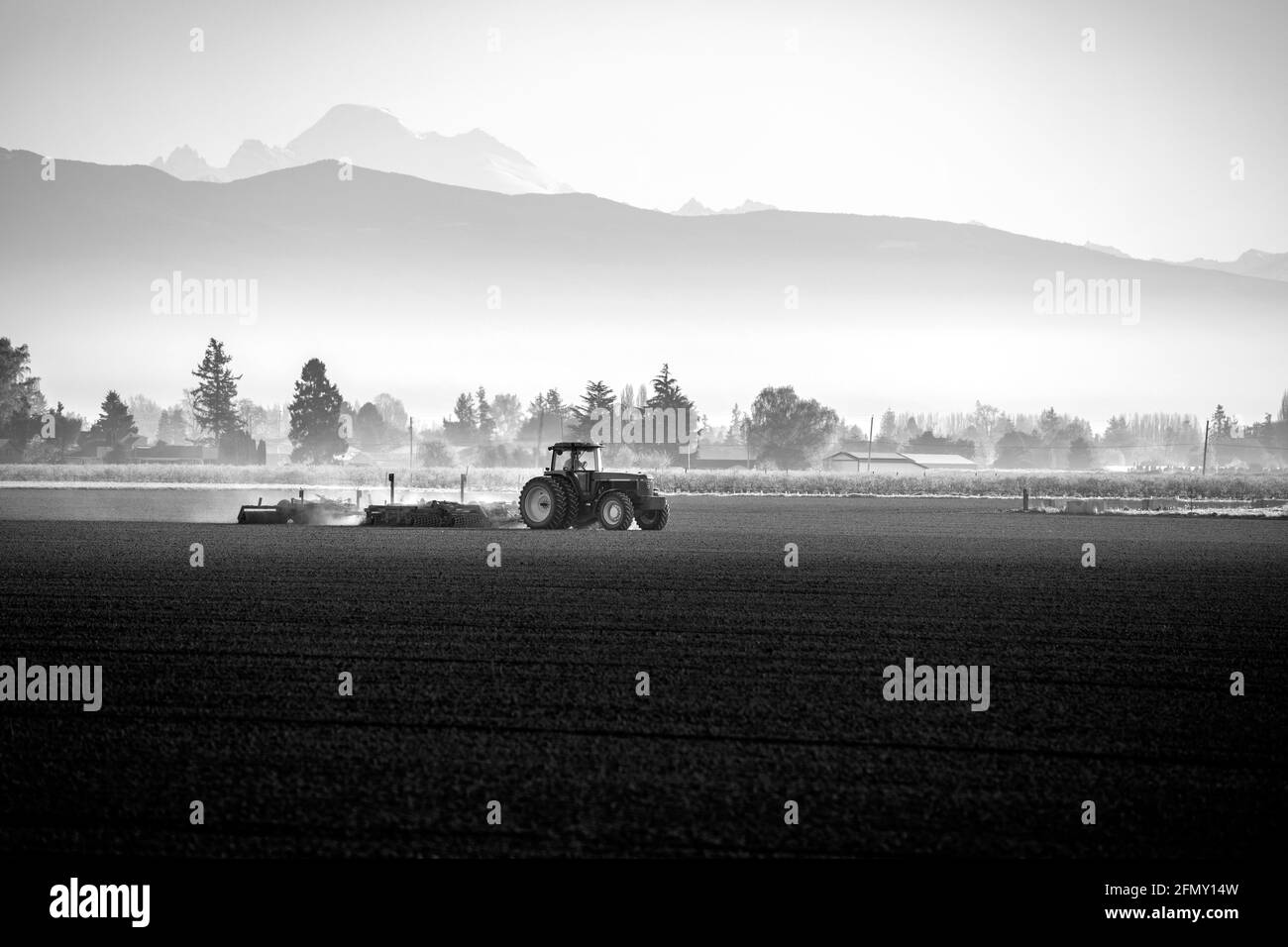 WA20192-00-BW...... WASHINGTON - trattore che aratura un campo nella valle di Skagit. Foto Stock