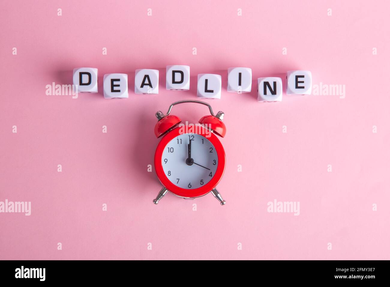 Lettere con un orologio rosso su sfondo rosa. Concetto di linea morta. Vista dall'alto. Foto Stock