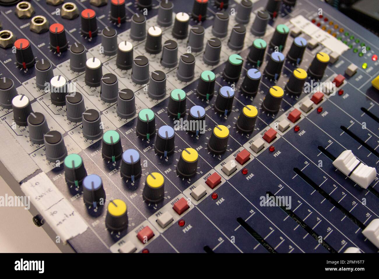 Primo piano di un mixer audio musicale in un evento all'aperto al coperto. Foto Stock