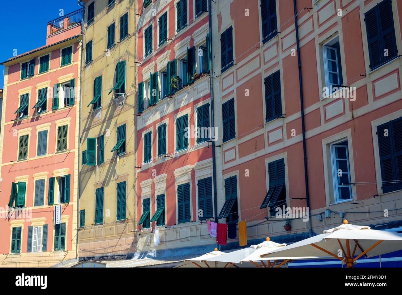 Facciate anteriori di una fila di alte case antiche a Camogli. Questi alti e colorati edifici sono tipici di questa città. Foto Stock