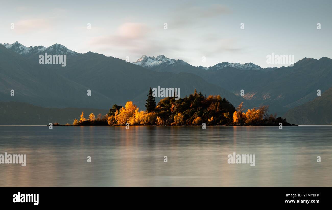 Autunno Isola Ruby illuminata dal sole Setting al Lago Wanaka, regione di Otago, Isola del Sud, Nuova Zelanda Foto Stock