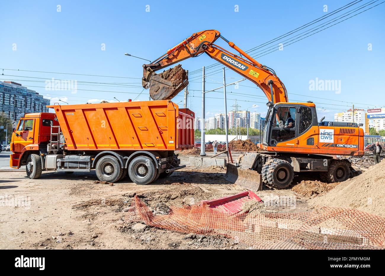 Samara, Russia - 6 maggio 2021: L'escavatore e il dumper stanno lavorando su un cantiere in estate Foto Stock