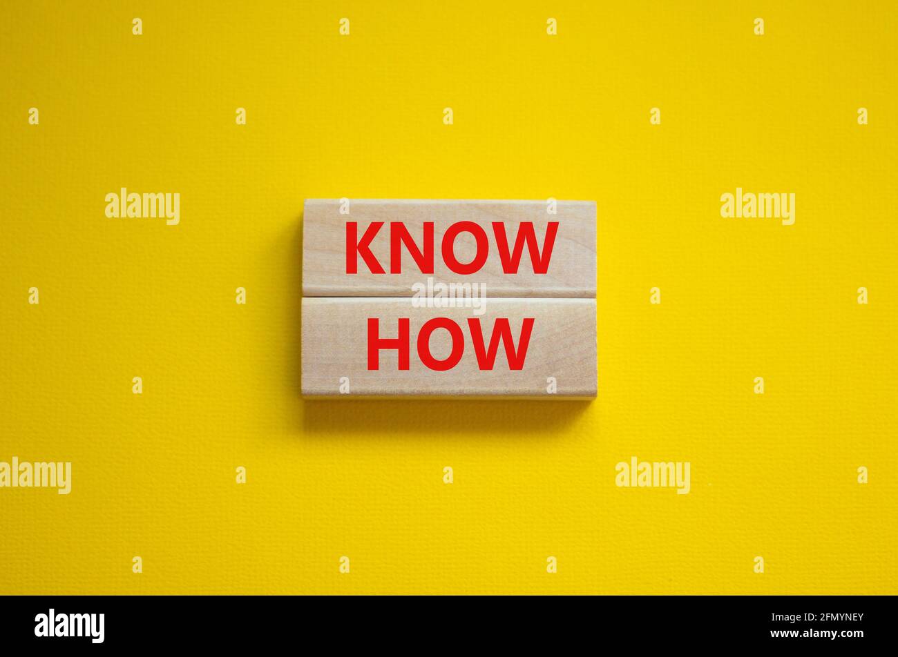 Conoscere il simbolo. Blocchi di legno con parole 'know how' su bello sfondo giallo, copia spazio. Business, innovazione e know how concetto. Foto Stock