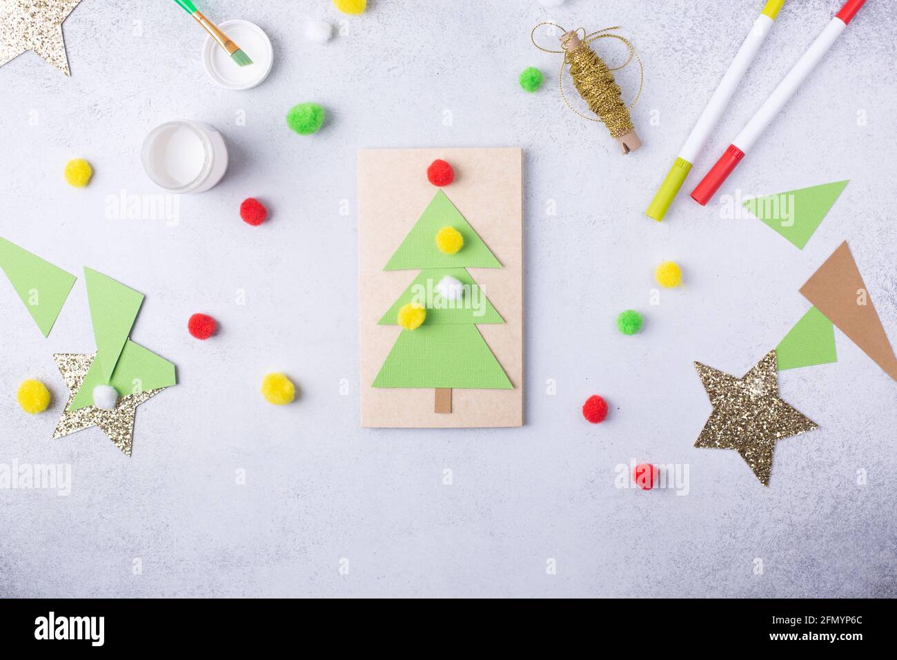 Il bambino fa un collage di carta di Natale del biglietto d'auguri. Bambini progetto d'arte artigianale per i bambini Foto Stock