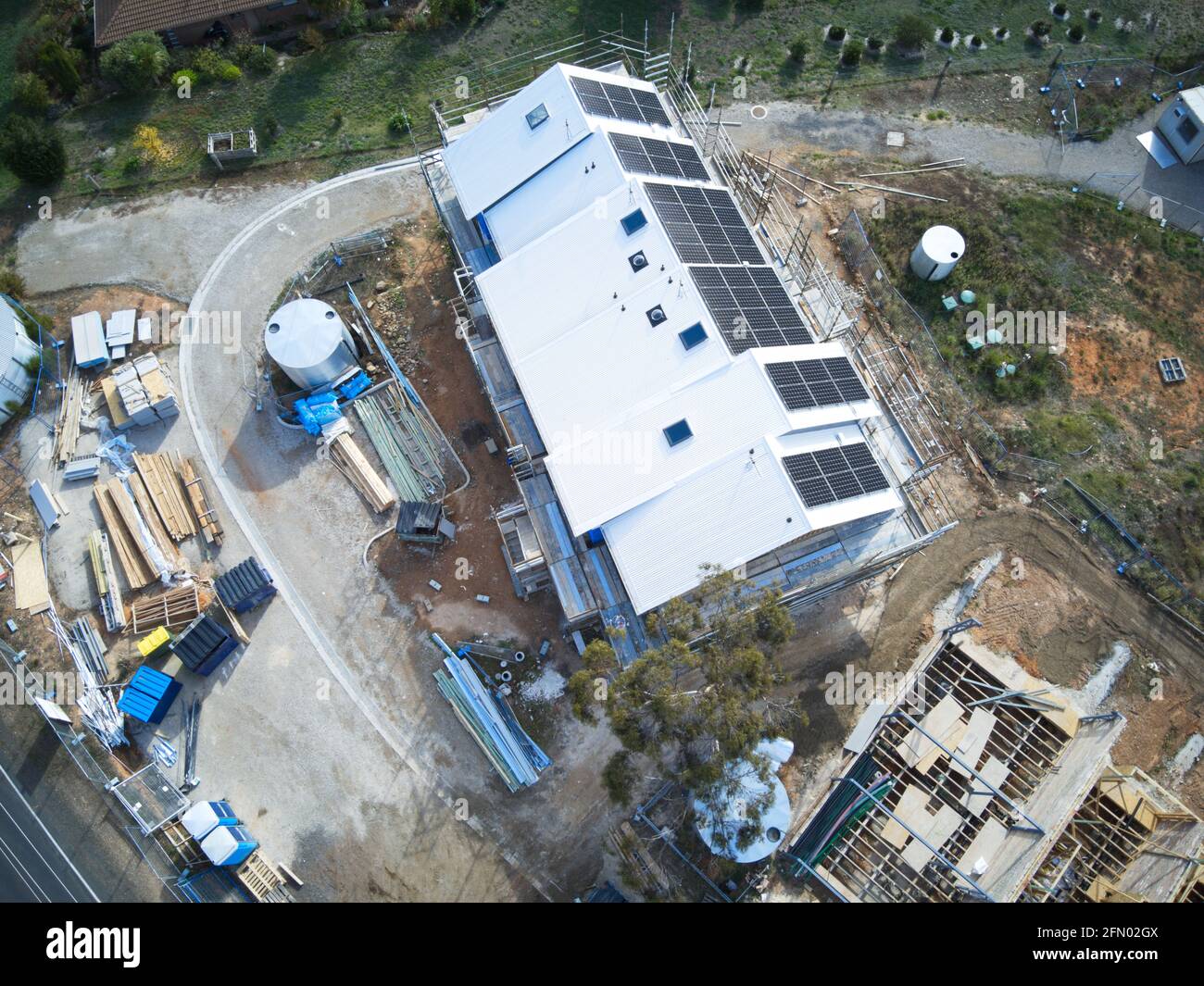Case ecologiche sostenibili in costruzione Vista aerea con pannelli solari e progetto di costruzione verde in un ambiente cespuglio, Castlemaine, Victoria, Australia. Foto Stock
