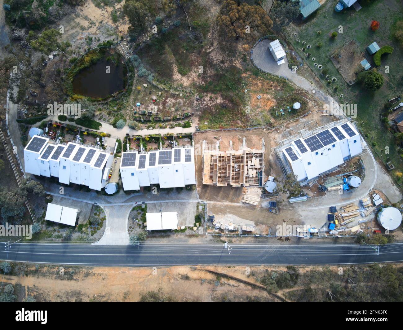 Case ecologiche sostenibili in costruzione Vista aerea con pannelli solari e progetto di costruzione verde in un ambiente cespuglio, Castlemaine, Victoria, Australia. Foto Stock