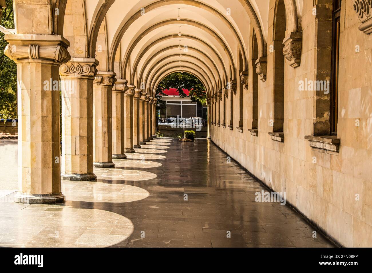 Grande colonnato in marmo con ombre e colonne ornate - prospettiva. Foto Stock