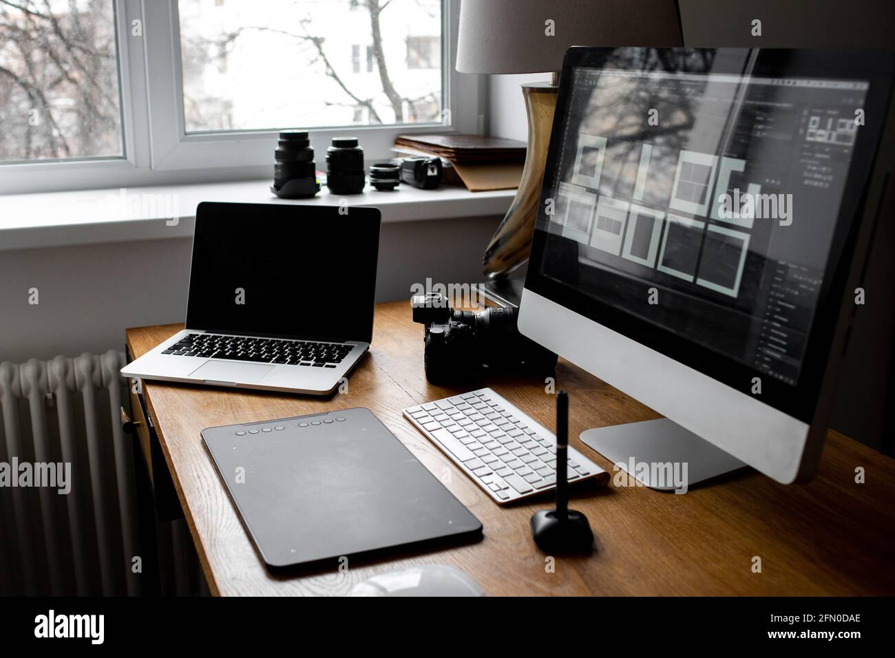 Spazio di lavoro elegante con computer portatile a casa o in studio. Luogo di lavoro del fotografo Foto Stock
