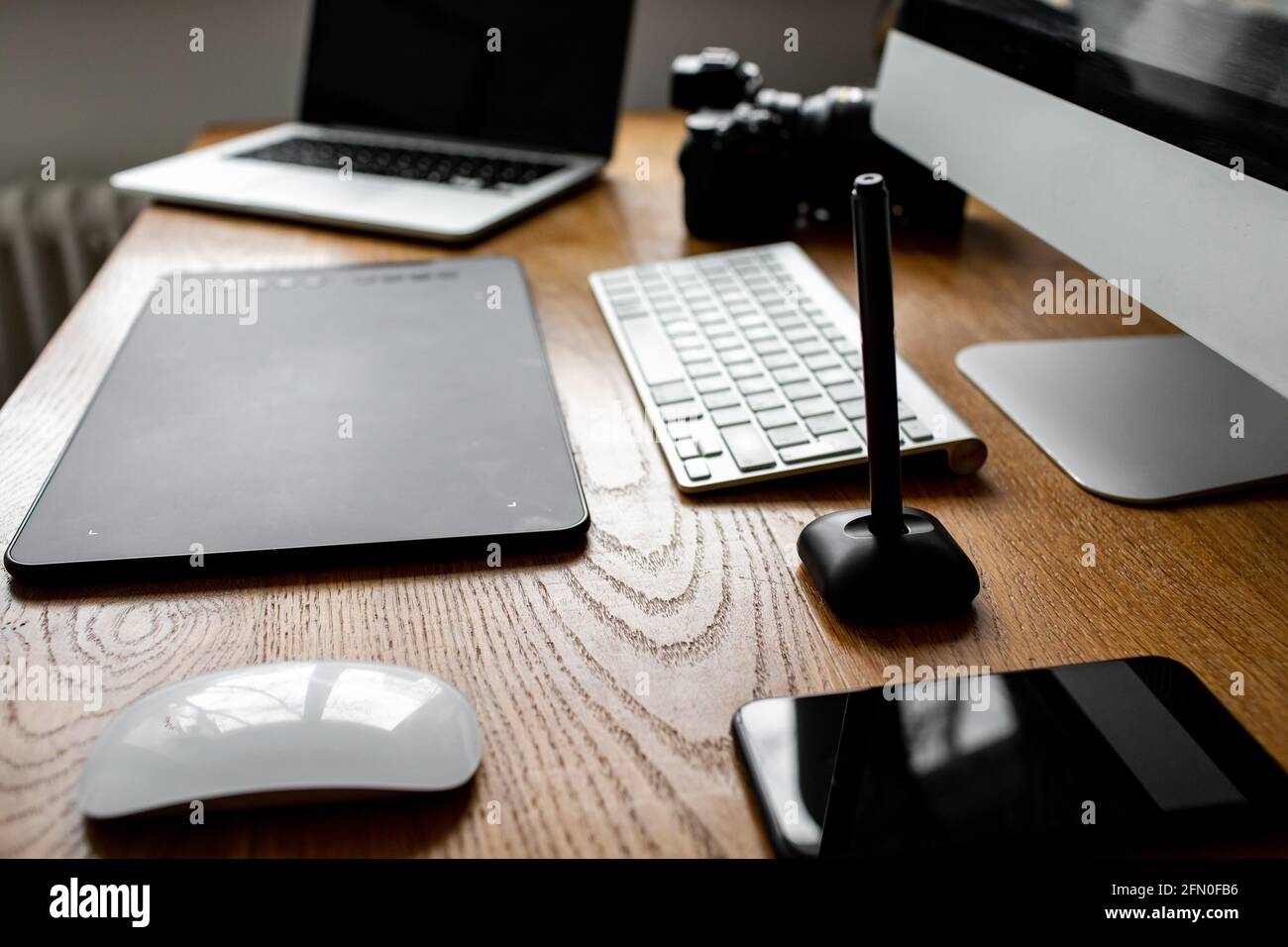 Spazio di lavoro elegante con computer portatile a casa o in studio. Luogo di lavoro del fotografo Foto Stock